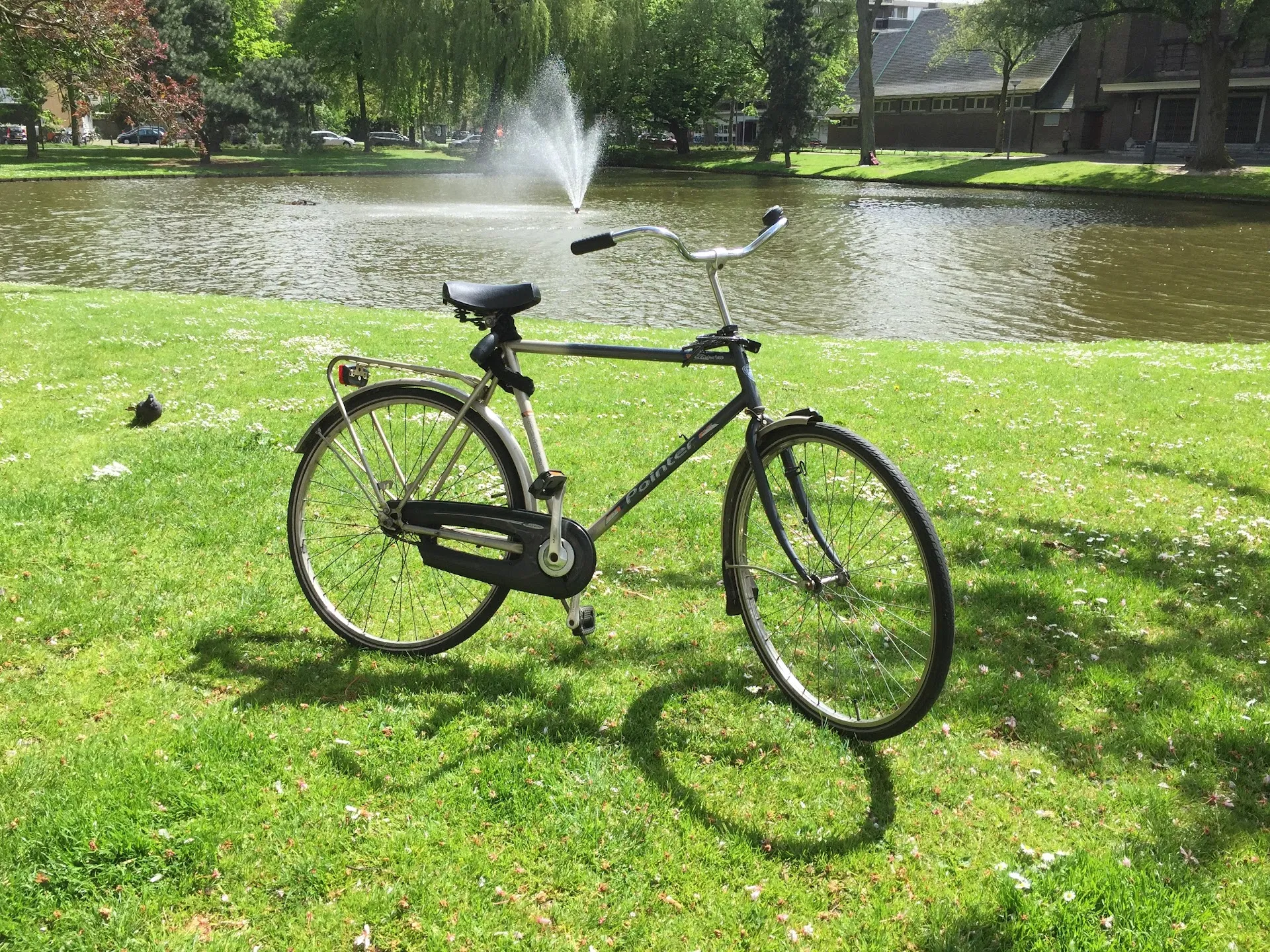 Dutch bike by a pond with fountain in Rotterdam park