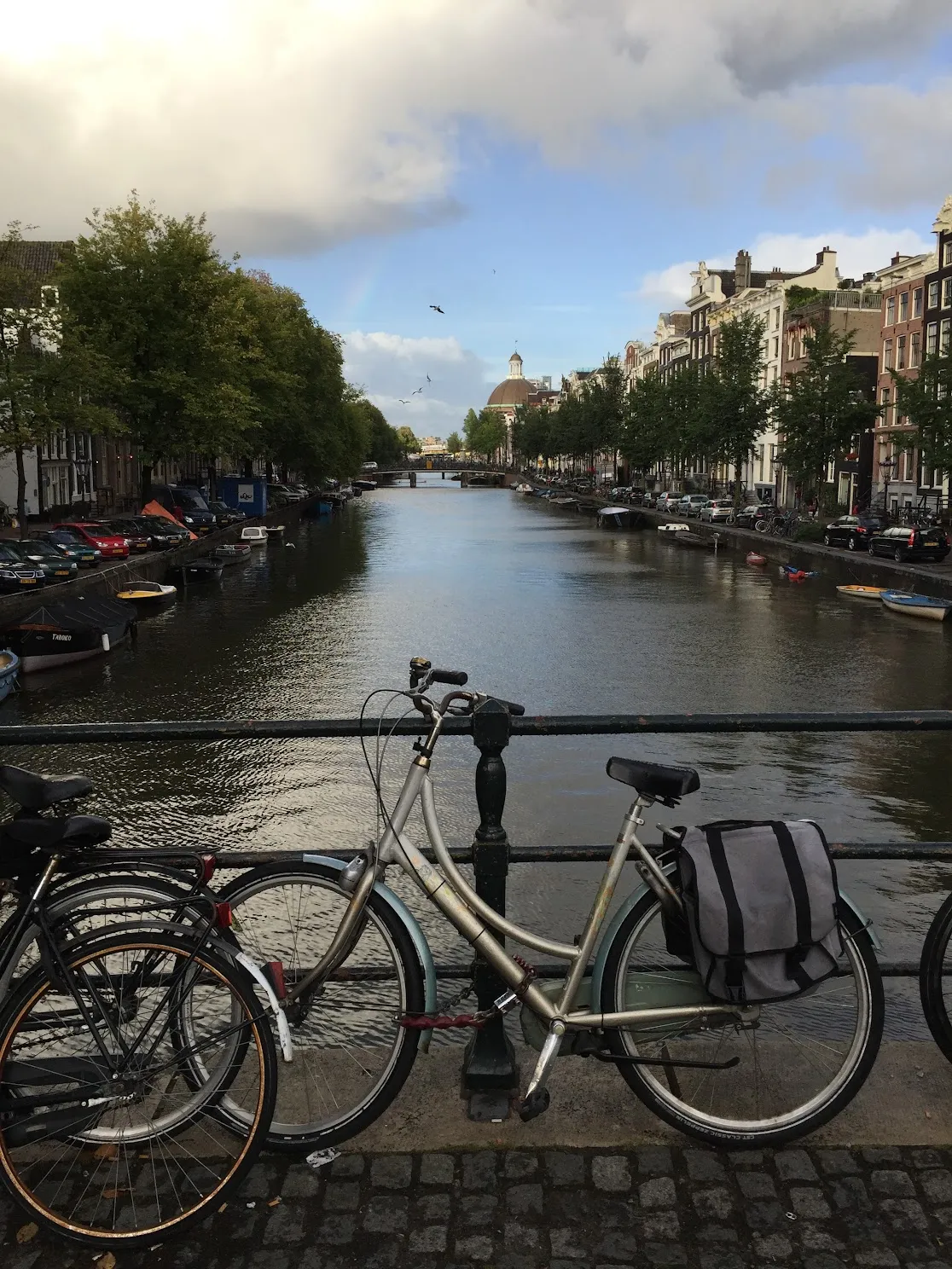 Bikes on a bridge over Amsterdam canal with traditional houses