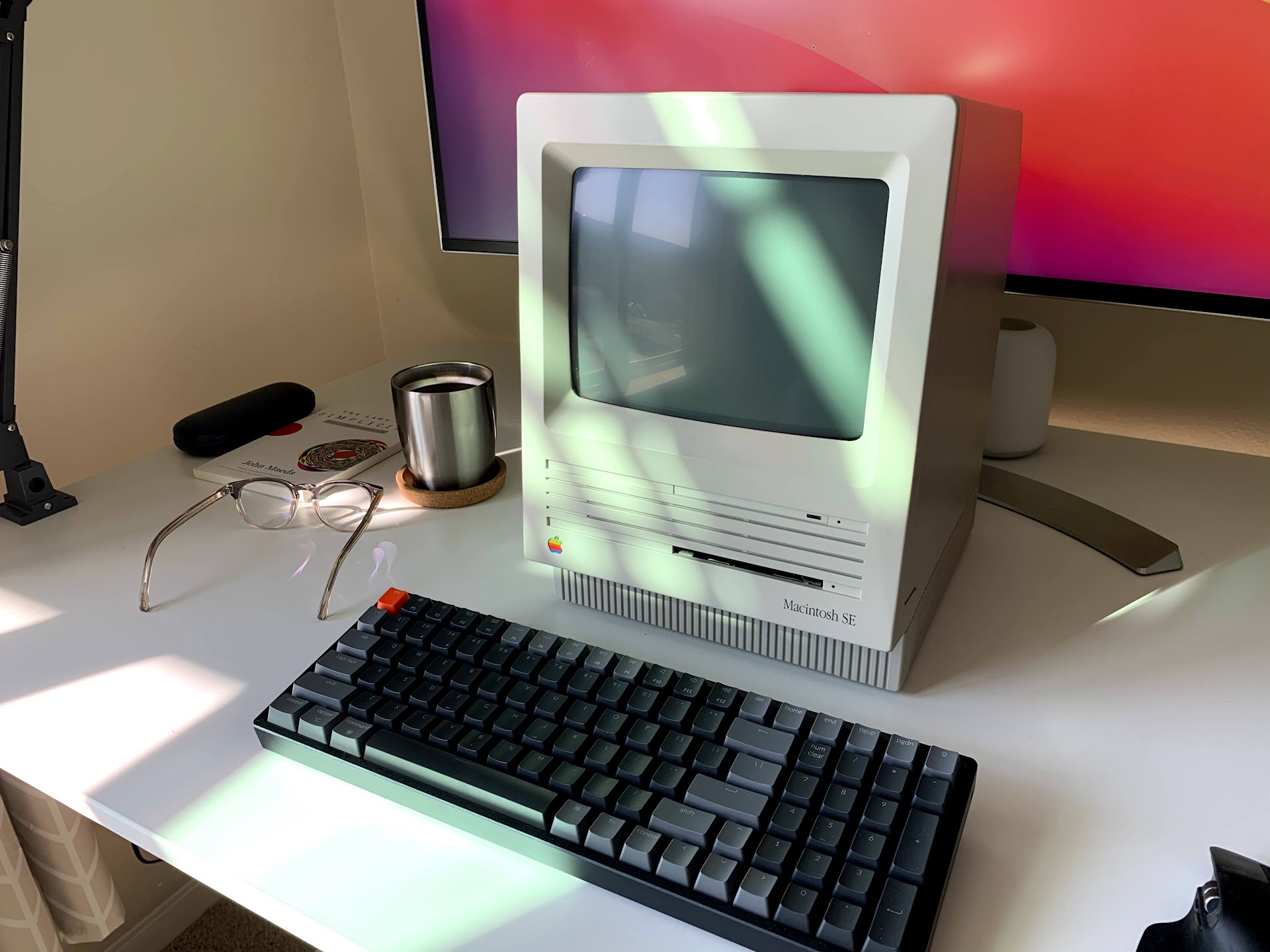 Vintage Macintosh SE on modern desk with mechanical keyboard